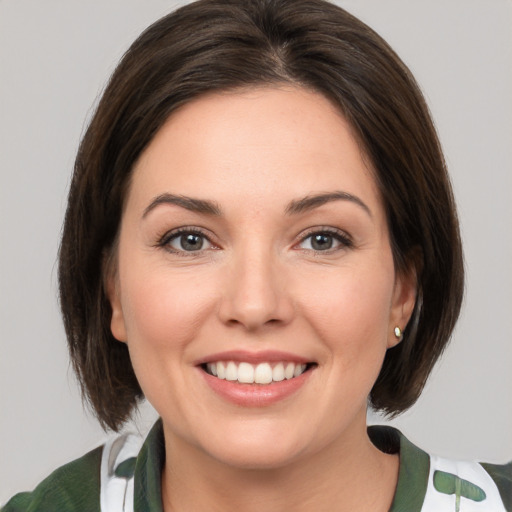 Joyful white young-adult female with medium  brown hair and green eyes