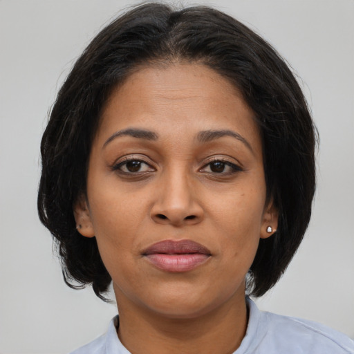 Joyful latino adult female with medium  brown hair and brown eyes