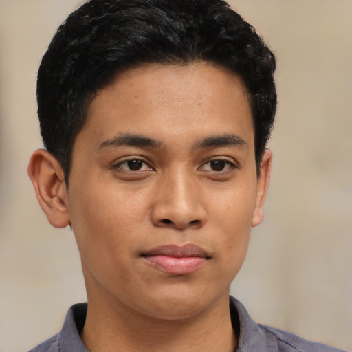 Joyful latino young-adult male with short  brown hair and brown eyes