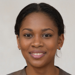 Joyful black young-adult female with long  brown hair and brown eyes