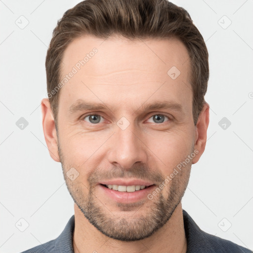 Joyful white young-adult male with short  brown hair and grey eyes