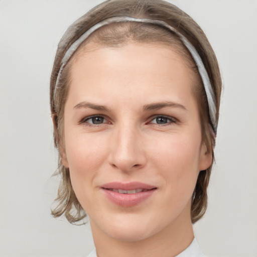 Joyful white young-adult female with medium  brown hair and grey eyes