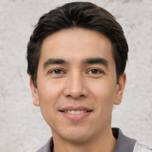 Joyful white young-adult male with short  black hair and brown eyes