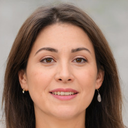 Joyful white adult female with long  brown hair and brown eyes