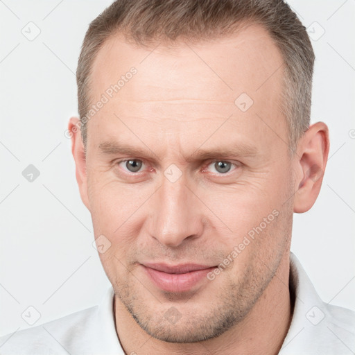 Joyful white adult male with short  brown hair and grey eyes