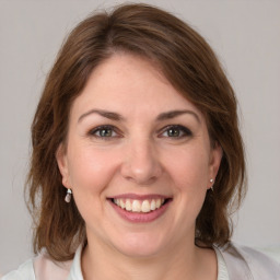 Joyful white young-adult female with medium  brown hair and grey eyes