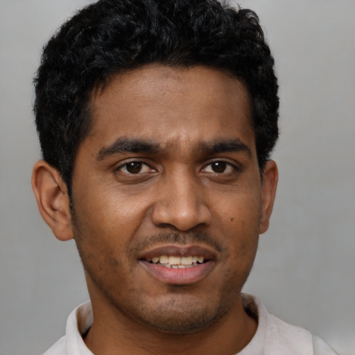 Joyful black young-adult male with short  black hair and brown eyes