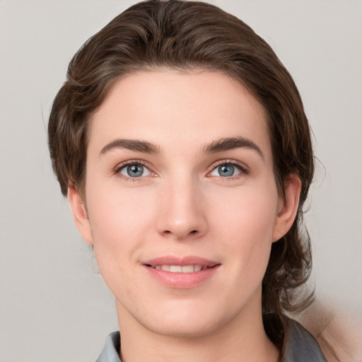 Joyful white young-adult female with medium  brown hair and grey eyes