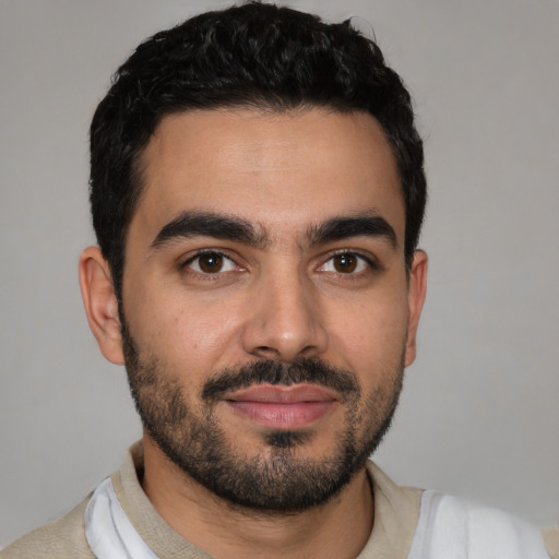 Joyful latino young-adult male with short  black hair and brown eyes