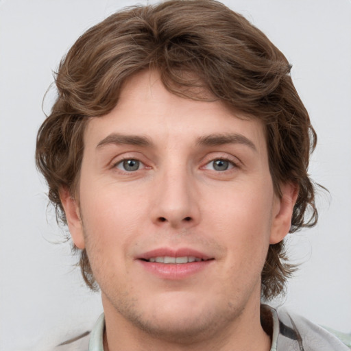 Joyful white young-adult male with medium  brown hair and grey eyes