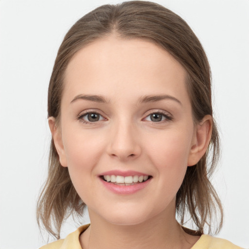 Joyful white young-adult female with medium  brown hair and grey eyes