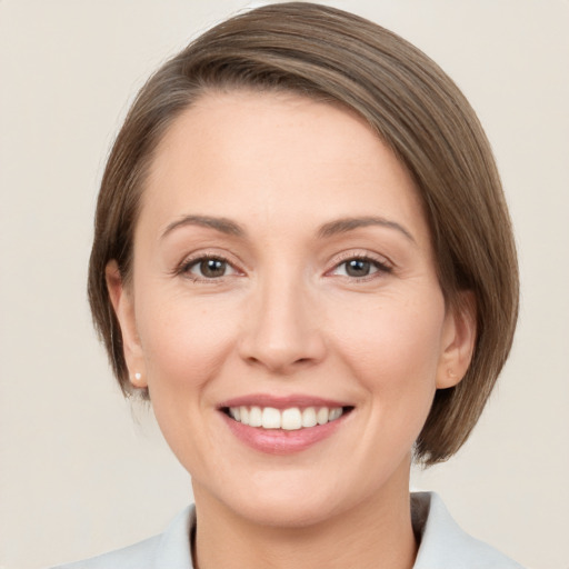 Joyful white young-adult female with medium  brown hair and grey eyes