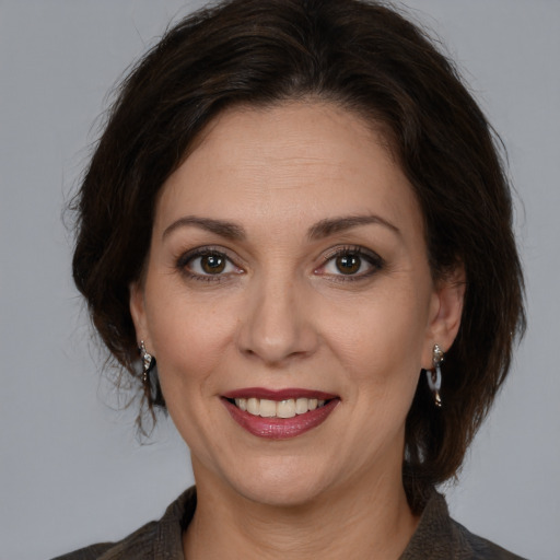 Joyful white adult female with medium  brown hair and brown eyes