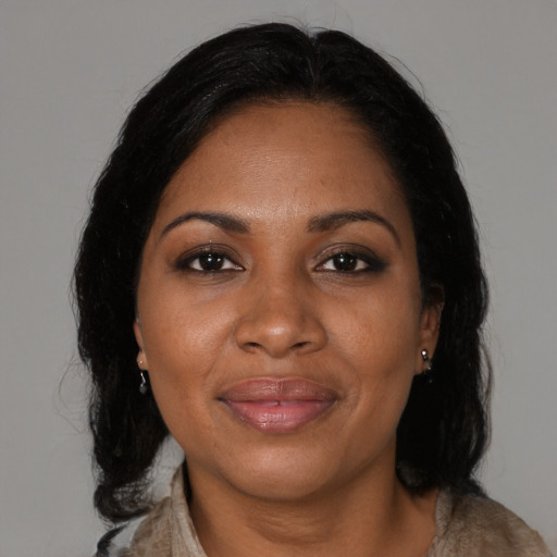 Joyful black adult female with medium  brown hair and brown eyes