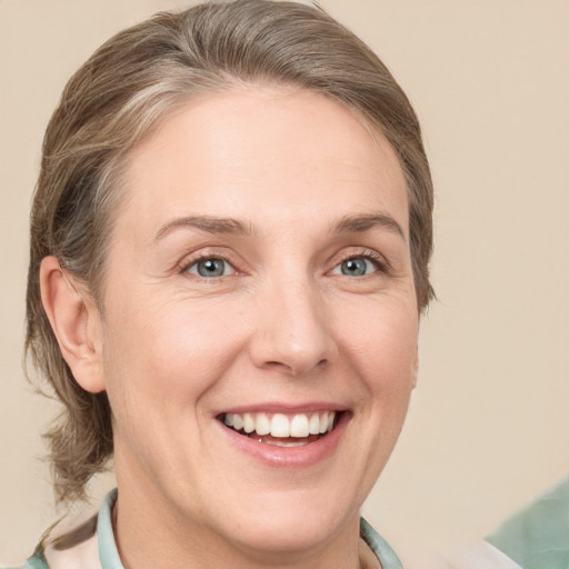 Joyful white adult female with medium  brown hair and grey eyes