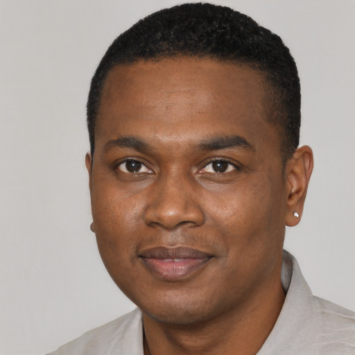 Joyful black young-adult male with short  black hair and brown eyes