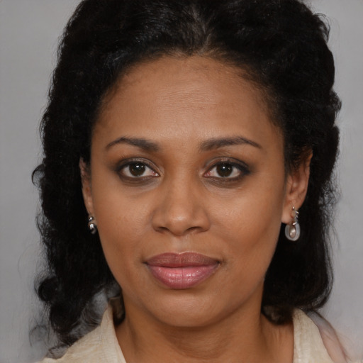 Joyful black adult female with medium  brown hair and brown eyes