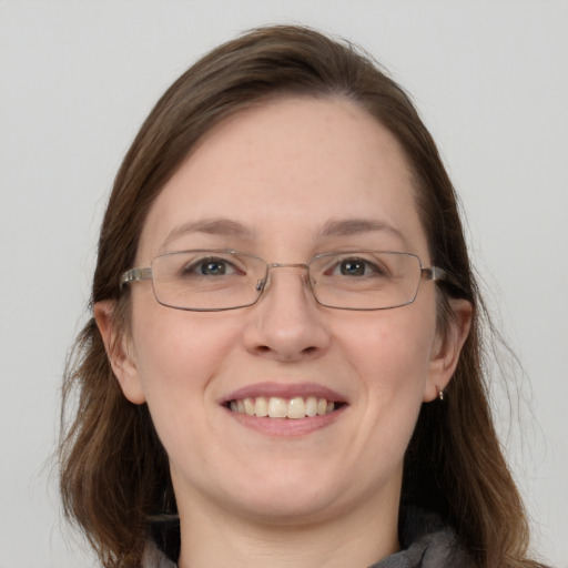 Joyful white adult female with long  brown hair and blue eyes