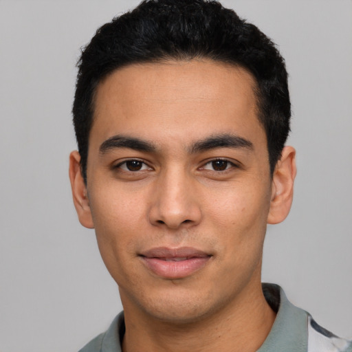 Joyful latino young-adult male with short  black hair and brown eyes