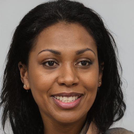 Joyful black adult female with long  brown hair and brown eyes