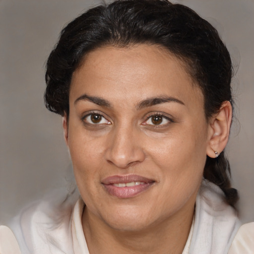 Joyful latino adult female with medium  brown hair and brown eyes