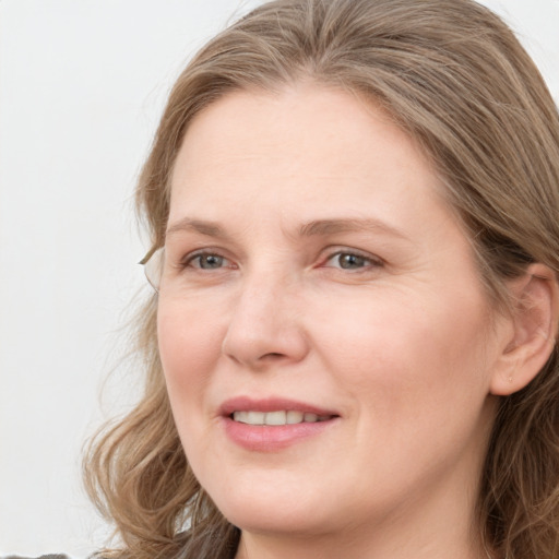 Joyful white young-adult female with long  brown hair and blue eyes