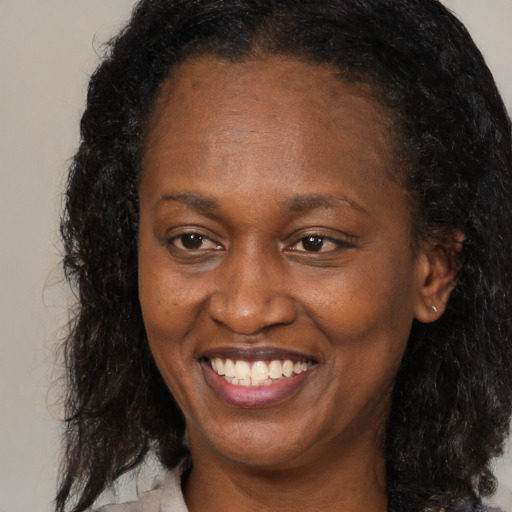 Joyful black adult female with medium  brown hair and brown eyes