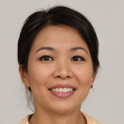 Joyful asian young-adult female with medium  brown hair and brown eyes