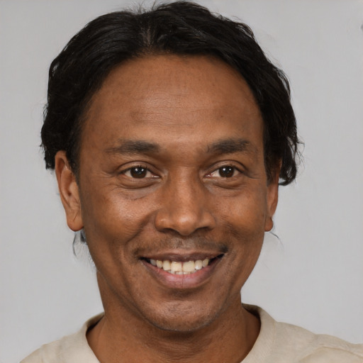 Joyful black adult male with short  black hair and brown eyes