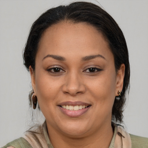 Joyful latino adult female with medium  brown hair and brown eyes