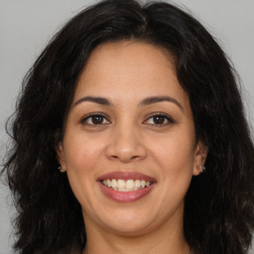 Joyful latino young-adult female with long  brown hair and brown eyes