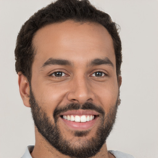 Joyful white young-adult male with short  black hair and brown eyes