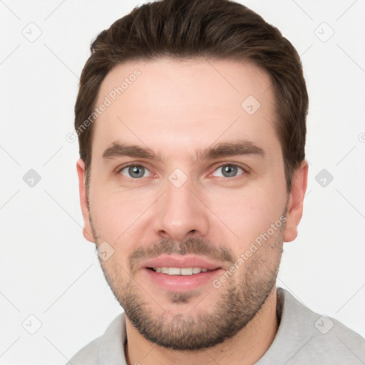 Joyful white young-adult male with short  brown hair and grey eyes