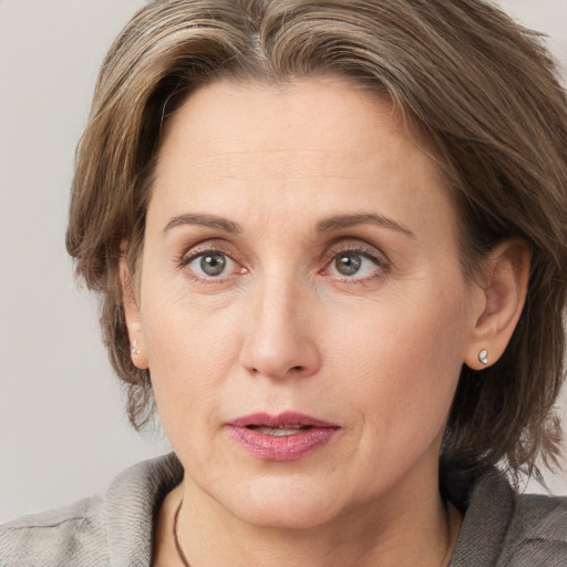 Joyful white adult female with medium  brown hair and grey eyes