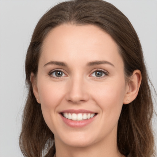 Joyful white young-adult female with long  brown hair and grey eyes