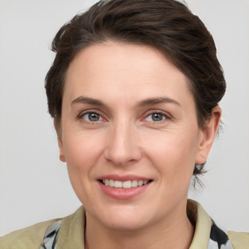 Joyful white young-adult female with medium  brown hair and grey eyes