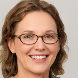 Joyful white adult female with medium  brown hair and blue eyes