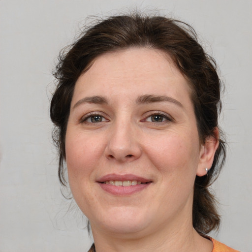 Joyful white adult female with medium  brown hair and grey eyes