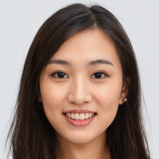 Joyful asian young-adult female with long  brown hair and brown eyes