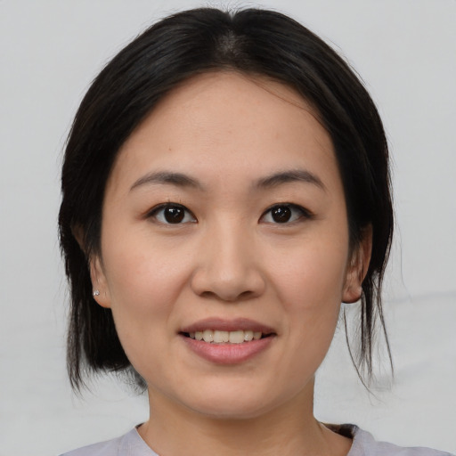 Joyful asian young-adult female with medium  black hair and brown eyes