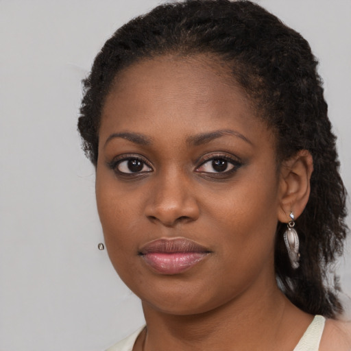 Joyful black young-adult female with medium  brown hair and brown eyes