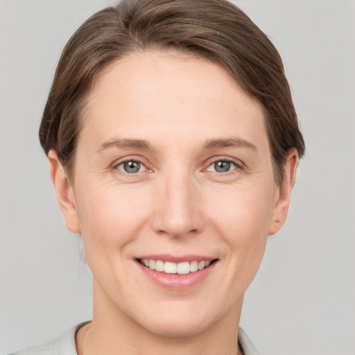 Joyful white adult female with short  brown hair and grey eyes