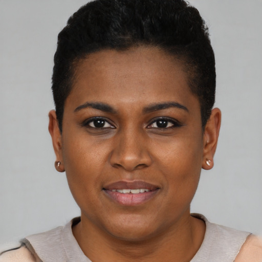 Joyful black young-adult female with short  black hair and brown eyes