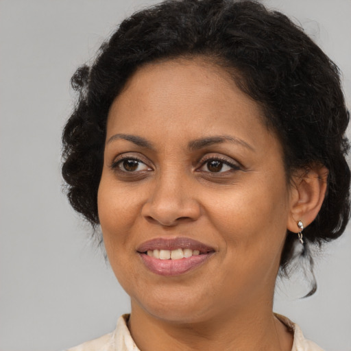 Joyful latino adult female with medium  brown hair and brown eyes