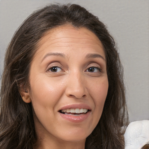 Joyful white adult female with long  brown hair and brown eyes