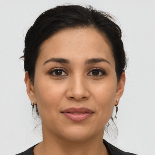 Joyful latino young-adult female with medium  brown hair and brown eyes
