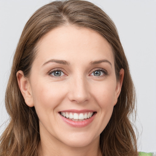 Joyful white young-adult female with long  brown hair and green eyes