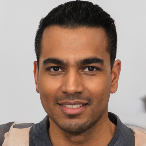 Joyful latino young-adult male with short  black hair and brown eyes