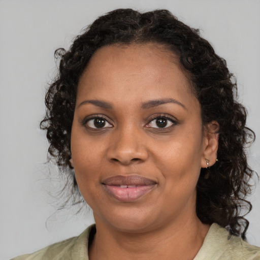 Joyful black young-adult female with medium  brown hair and brown eyes