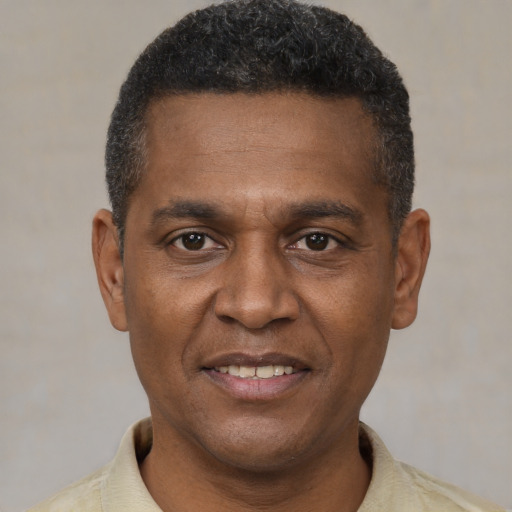 Joyful black young-adult male with short  brown hair and brown eyes
